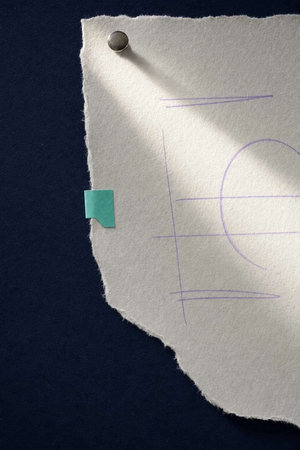 A torn sheet of paper with lavender research marks pinned to a navy surface
